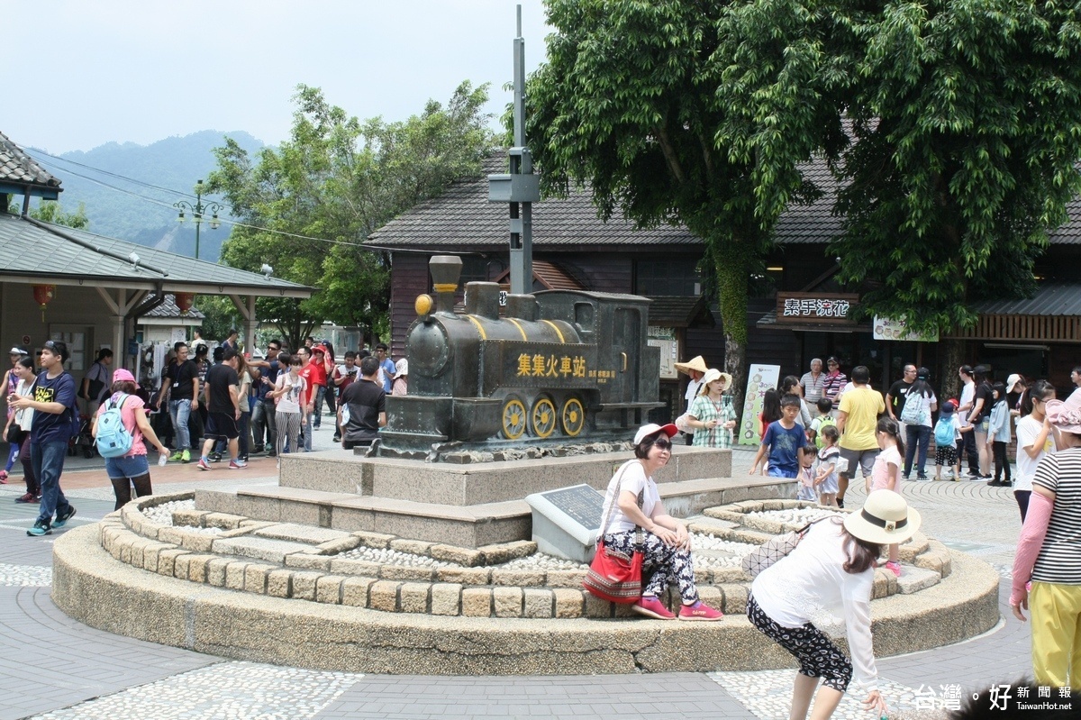 遊集集，遊客們喜在集集火車站前的小火車頭前合影留念。