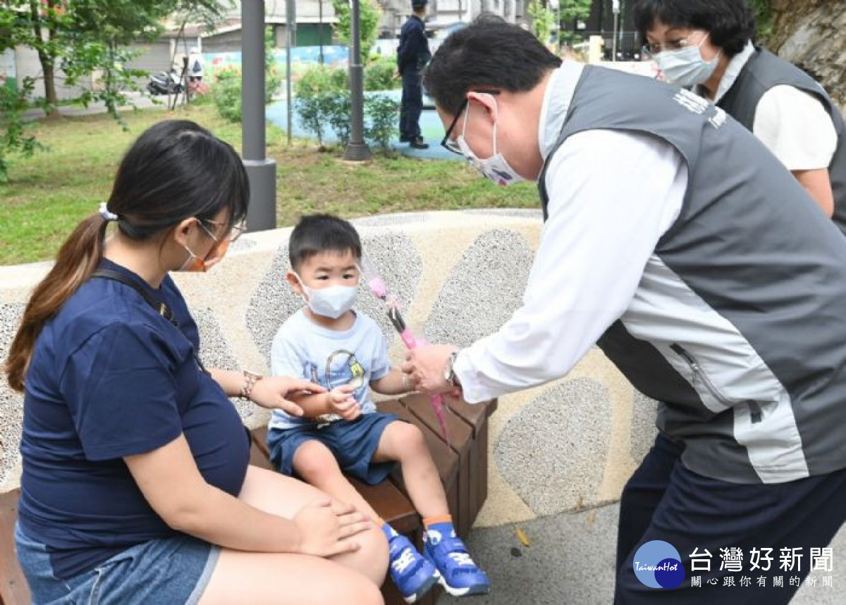 市長在內壢社福館前方的常樂公園，與親子互動並送上康乃馨。