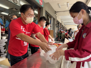 台中市議員謝志忠（左一）受邀擔任一日店長，協助「粥狂」發送2000碗海鮮粥。