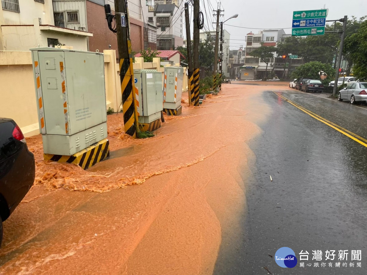 滾滾紅土泥流淹沒柏油路面，危及居民通行安全。