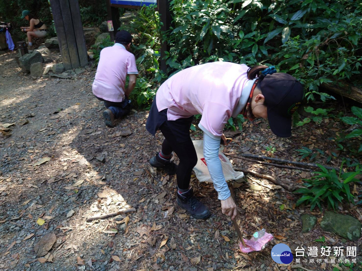 淨山志工撿拾東卯山步道沿線垃圾。