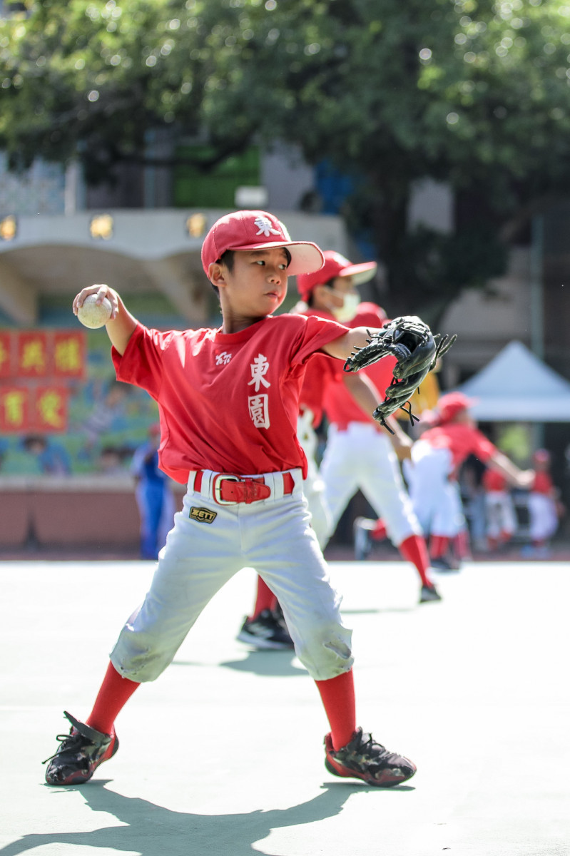 臺北市東園國小棒球隊球員專注進行傳接球訓練。