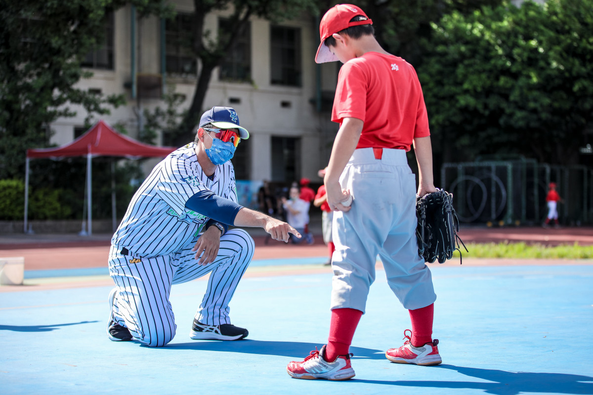 臺北興富發棒球隊球員蘇俊榮（左一）指導東園國小棒球員調整投球姿勢。