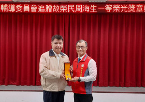 輔導會李文忠副主委(左)追贈故榮民周海生一等榮光專業獎章，由處長周興國(右)代表受領