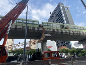 台中捷運行駛中列車遭旁邊超高大樓高空作業斷裂的吊車吊臂砸中造成一死八傷重大意外。消防局提供