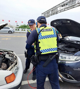 車輛拋錨熄火路中央，員警以巡邏車電瓶跨接方式協助接電／警方提供