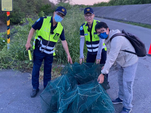 保七警攜手台江處，協助清除河道裡捕捉魚蟹之蜈蚣網