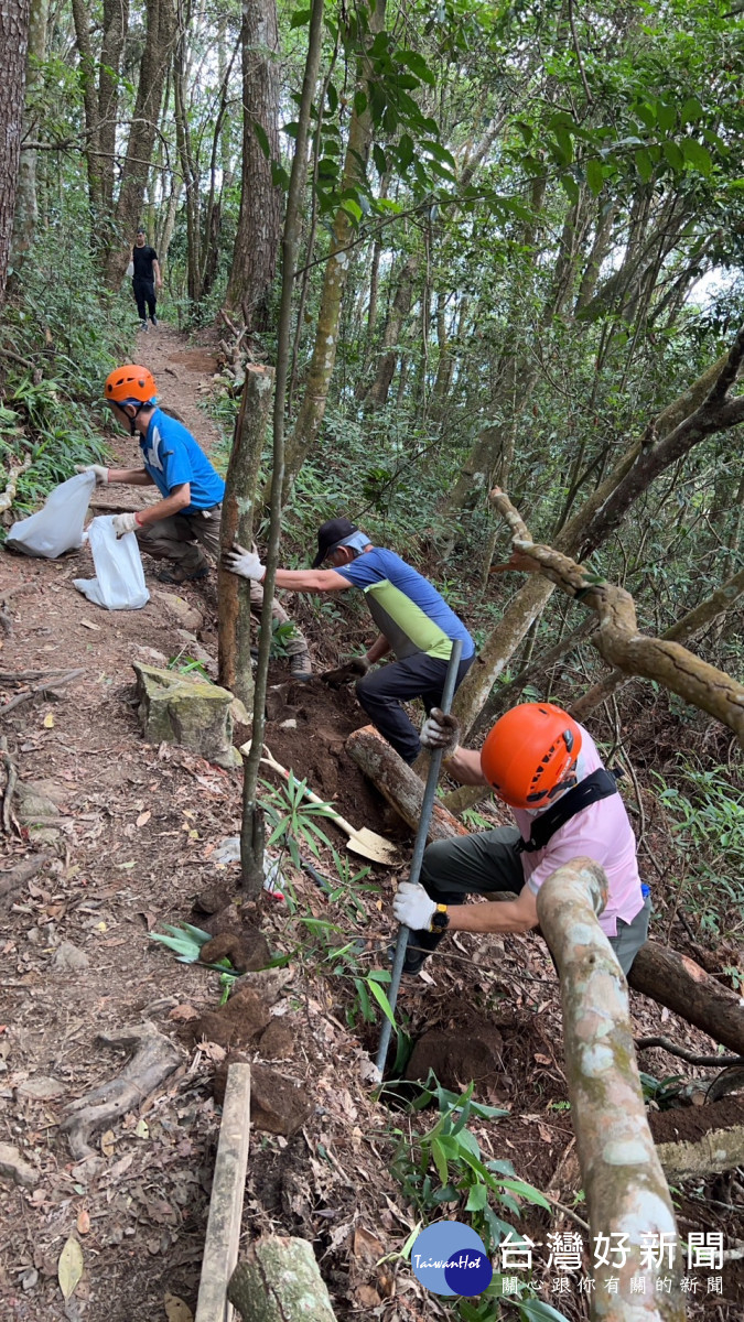 步道志工利用現地枯倒木進行護坡工程。