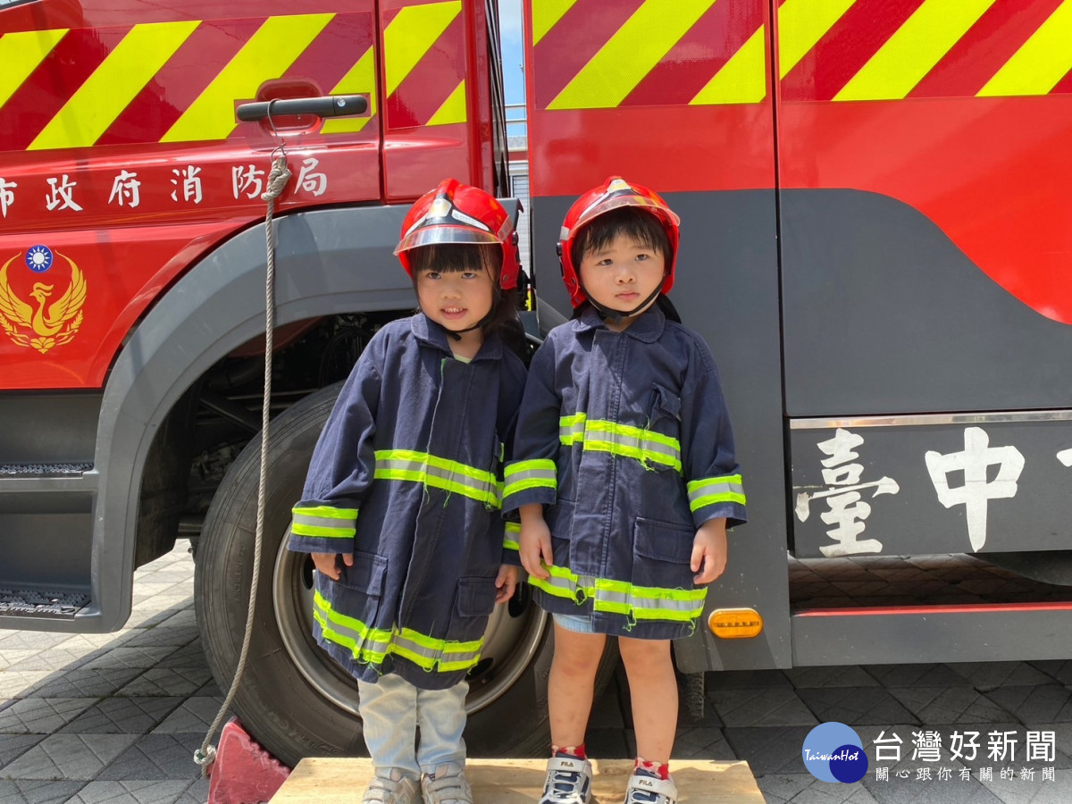 學童穿著兒童版消防員正式裝備，模樣可愛。