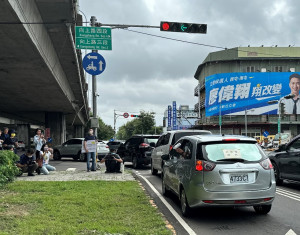 台中市環保局在車輛易丟棄垃圾的熱點-南屯區向上路與環中路交叉口，設置24小時路口監視器-中市環保局模擬汽車丟垃圾場景。(圖/生活中心攝)