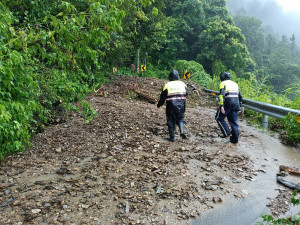 警員劉尚哲與古皓瑋冒雨進入山區。（仁愛分局提供）