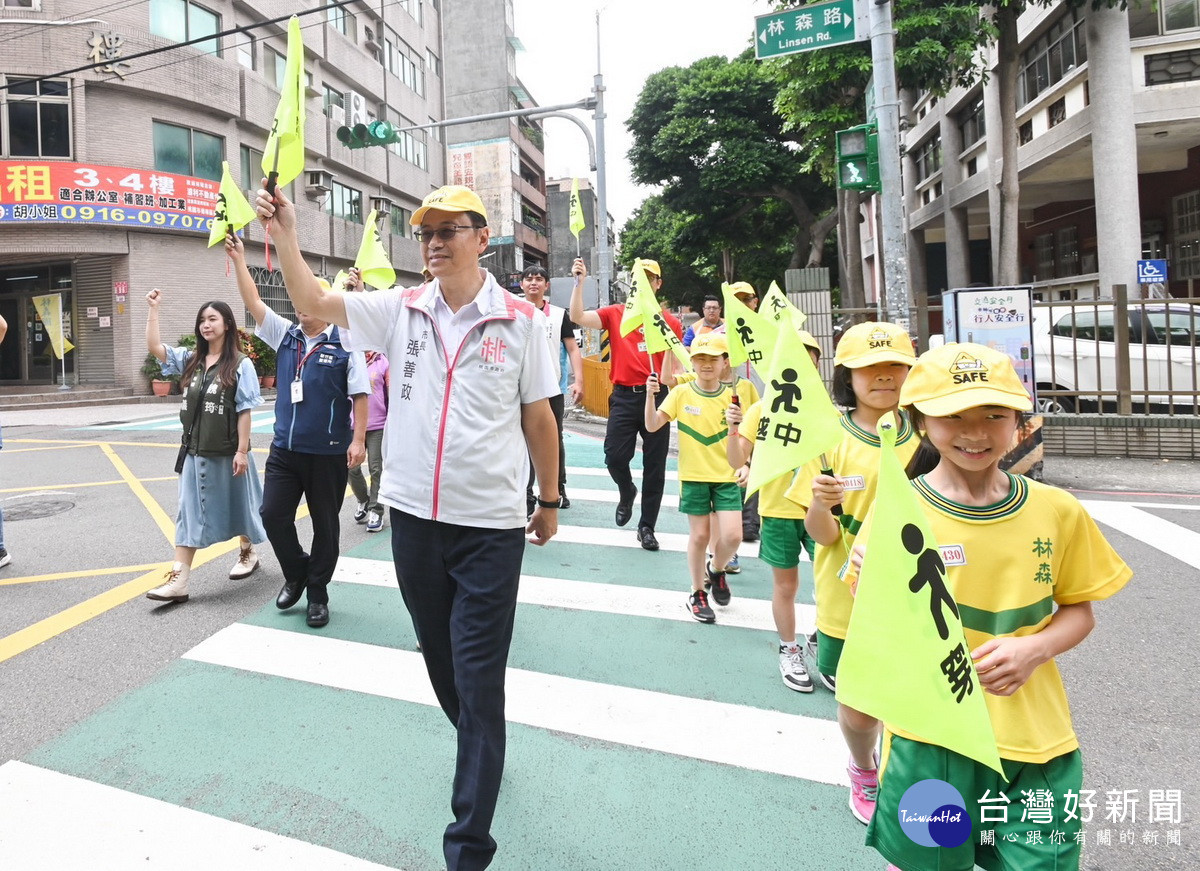 桃園市長張善政出席「112年交通安全月校園宣導」活動，陪同小朋友們手持「小黃旗」過馬路。