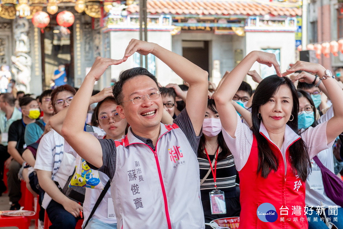 桃園市副市長蘇俊賓、立委萬美玲出席景福宮「桃園大廟遇到愛．月老牽線賜良緣」未婚聯誼活動中比出愛心。