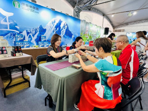 信義鄉農會在南投世界茶業博覽會的茶香產業館設置攤位，吸引愛喝茶的民眾停下腳步品嘗玉山茶區的特有茶香。（圖/記者賴淑禎攝）