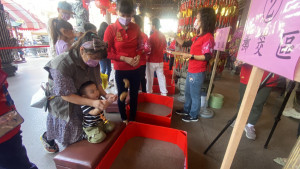 潭水亭觀音媽廟舉辦擲筊大賽，年僅3歲男童在家長指導下體驗。