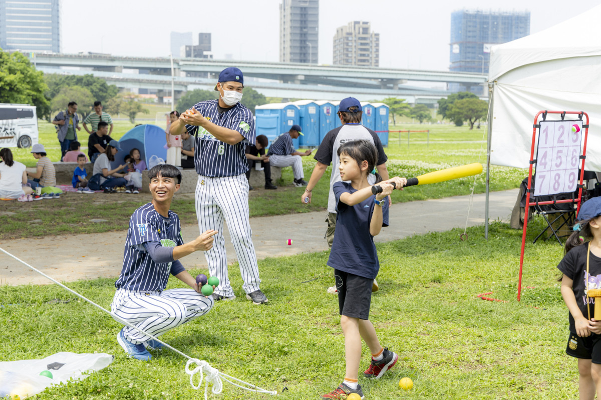 臺北興富發棒球隊球員耐心指導小朋友進行樂樂棒球打擊訓練。