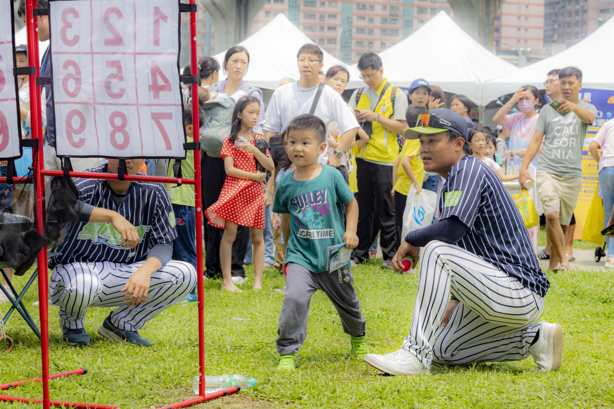 臺北興富發棒球隊球員帶領小朋友投玩棒球。