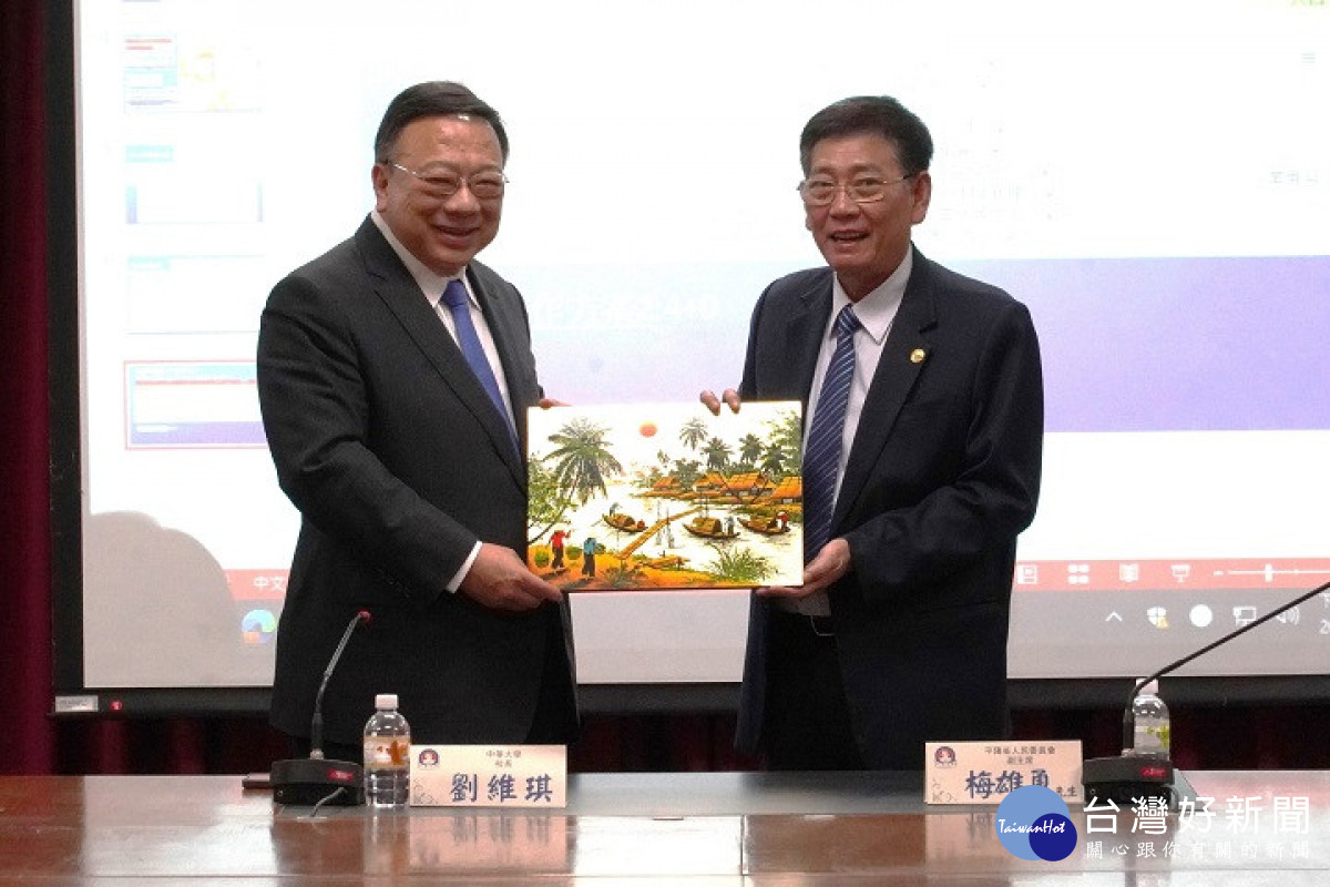 越南平陽省政府常務部梅雄勇主席（左）贈送越南畫給中華大學校長劉維琪（右）。