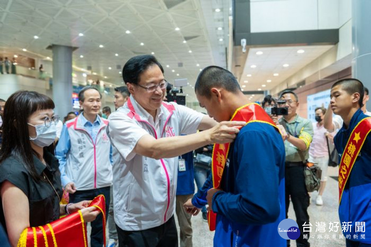 張市長逐一為返國代表隊成員頒贈花圈及桃園之光背帶。<br />
