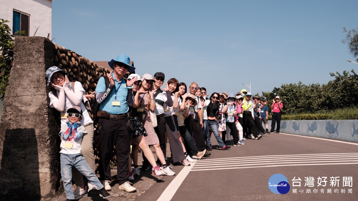 參與民眾在海墘社區圍牆前俏皮合影。