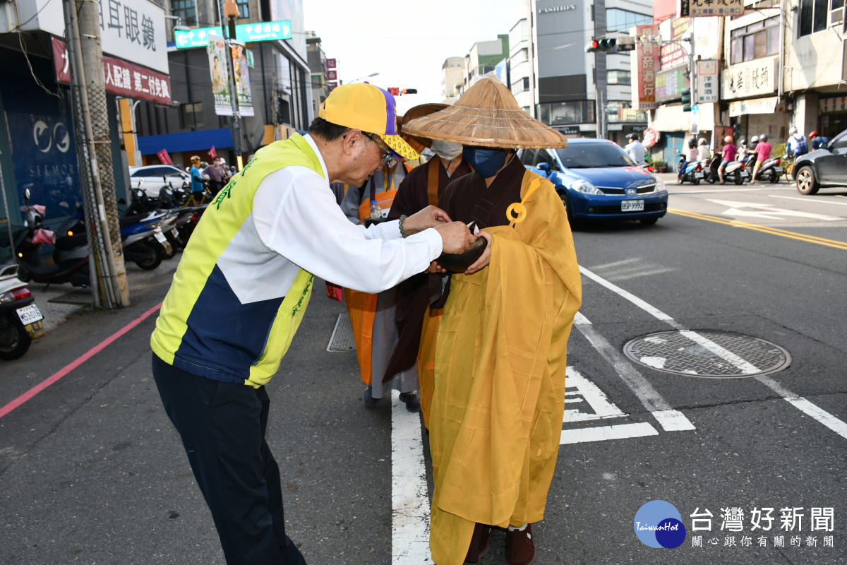 林世賢市長率先敬戲現金入化緣師父手持的缽內。圖／記者鄧富珍翻攝