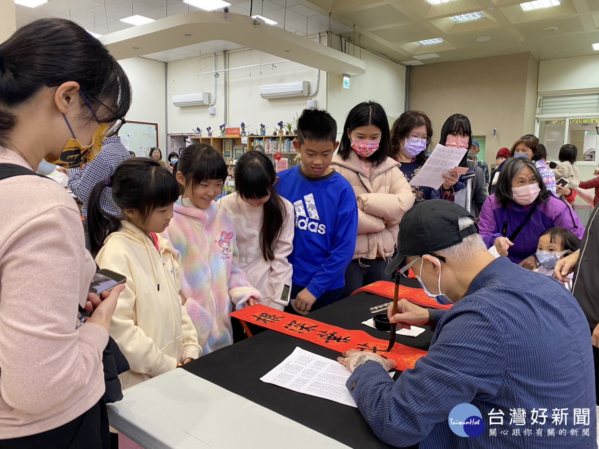 彰化市立圖書館現場揮毫送春聯，現場民眾大排長龍。圖／記者鄧富珍攝