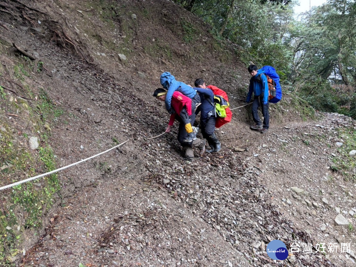 由2梯次搜救人員持續揹負傷者下撤，於27日13時18分下撤至登山口，並由玉山91後送至竹山秀傳醫院就醫。。（消防局提供）