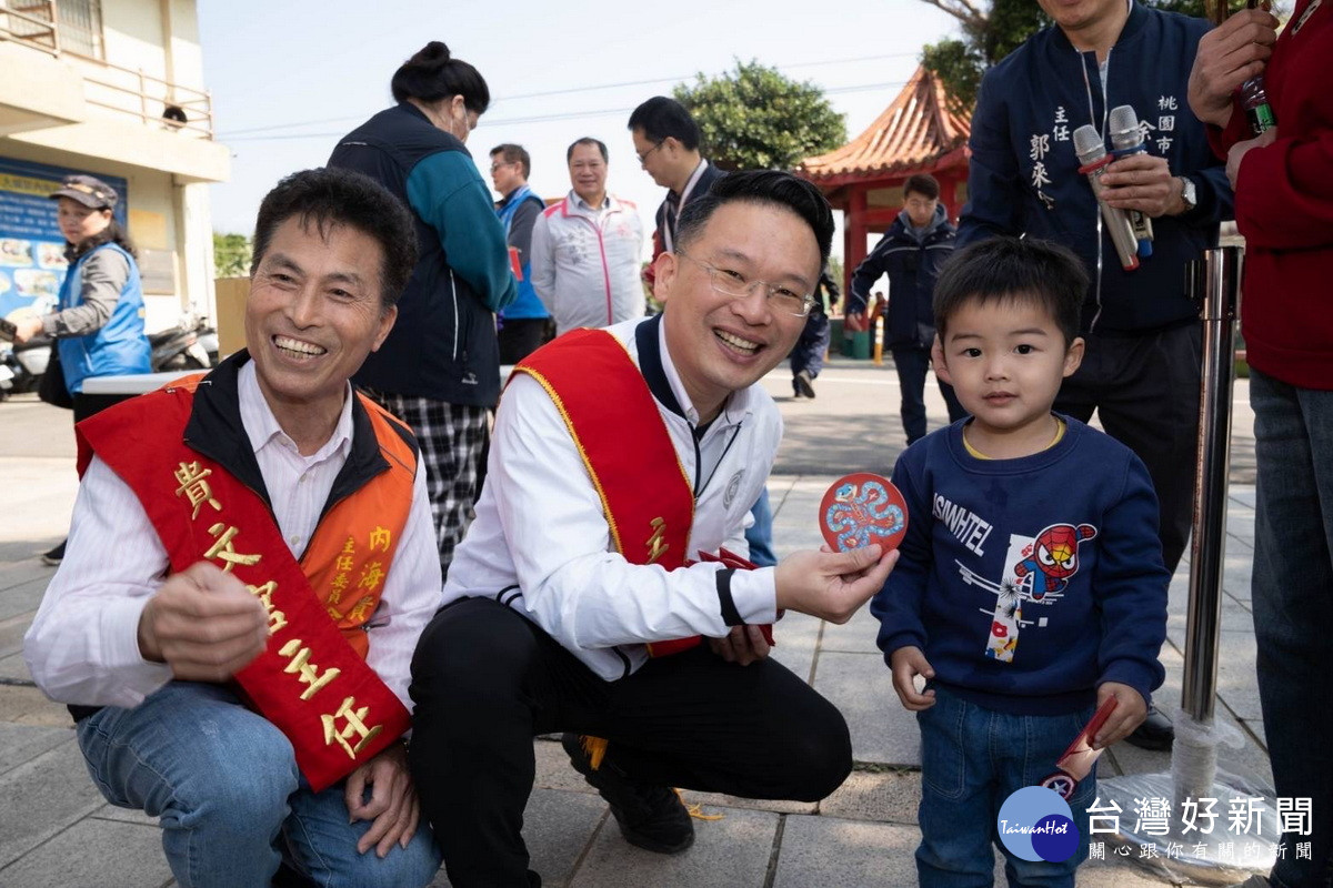 桃園市副市長蘇俊賓於大園內海貴文宮遶境祈福儀式中發放新春福袋。