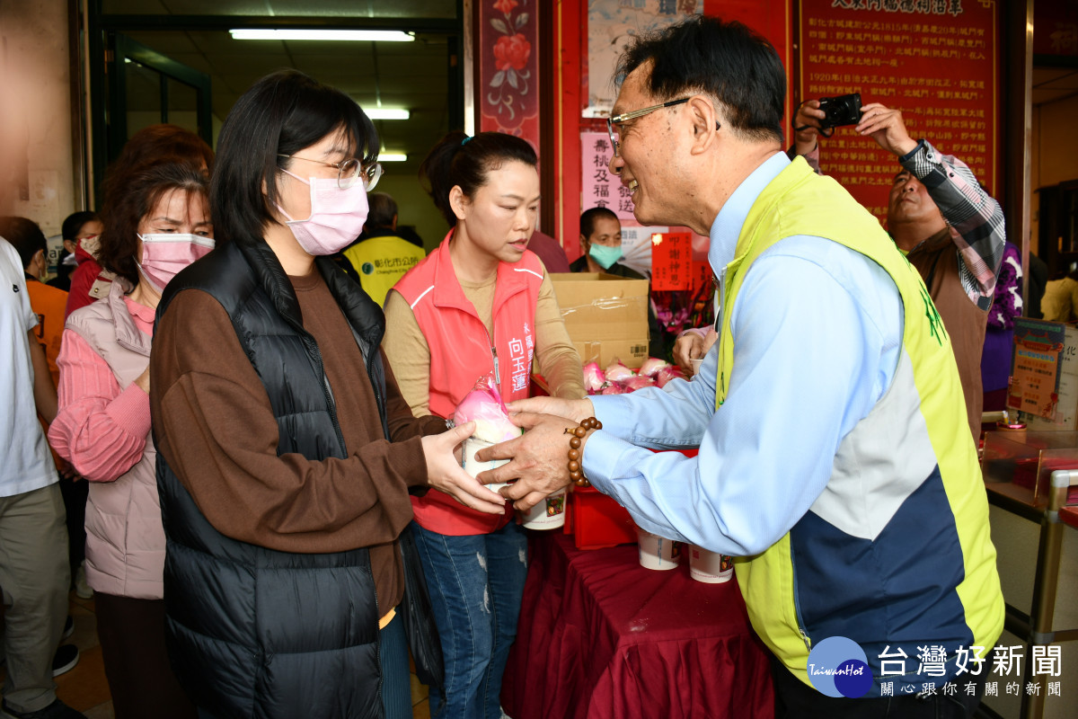 林世賢市長逐一發送壽桃與紅豆紫米桂圓粥給民眾分享慶祝土地公生的喜悅。圖／記者鄧富珍翻攝