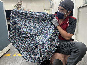 北區清潔隊以回收廢棄雨傘傘面，製成購物袋及飲料杯帶。