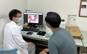 圖黃詮博醫師向病人詳細說明幽門螺旋桿菌感染部位及治療方式。