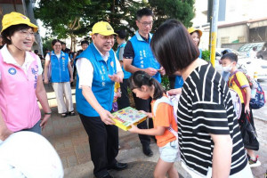 副縣長陳見賢配戴小黃帽，在竹北市六家國小門口向學生發送交通安全小禮物。
