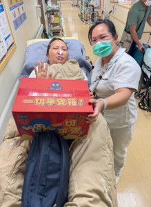 邱容萱護理師(右)送上台灣特產「乖乖」，希望患者一路平安。