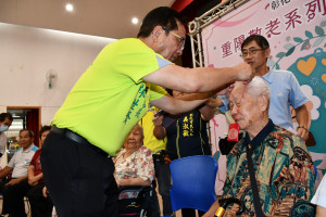 林世賢市長親切地為102歲的張起龍掛上金鎖片。圖／記者鄧富珍翻攝
