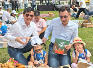 台中市客委會主委江俊龍(左)參加2025臺中市民野餐日記者會，推薦貓頭鳥繪本。