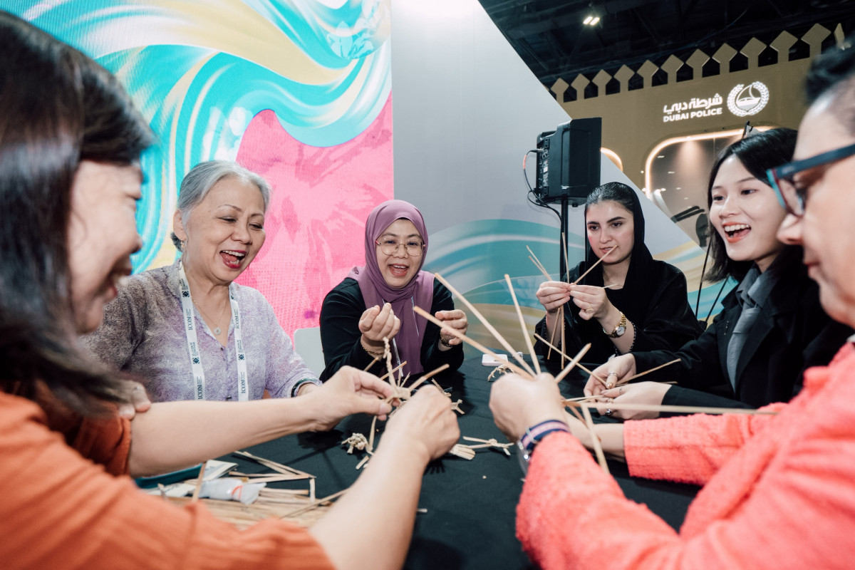 來自不同種族、宗教的參觀人士來到臺灣館了解傳統文化,並且由藺草編織工藝師呂錦霞帶領進行客家藺草編織體驗 。(圖/中華民國博物館學會)