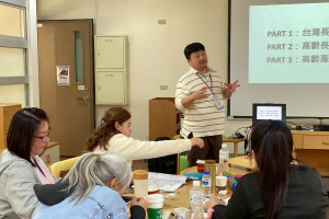 老福系助理教授許孟爵（立者）向馬來西亞長照參訪團介紹台灣長照經營模式。（弘光科大提供）