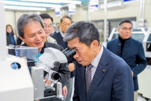 一關市市長佐藤善仁（前）於參訪過程中，聆聽明新科大副教務長高國檳（左一）介紹半導體實作教學設備與產學研發應用。