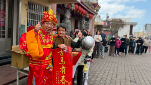 謝志忠特別穿財神爺裝送春聯，民眾紛紛排隊合照，年味滿滿。