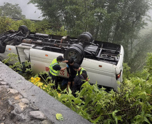 中巴衝出道路翻覆，警消處理中。（仁愛分局提供）