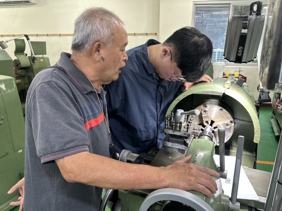 CNC數控工具機實務技能班，老師指導訓練學員操作機台。