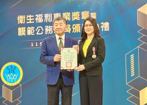 行政院政務委員陳時中(左)，頒發衛福部「115年衛生福利專業獎章」予暨大吳書昀教授(右)。（暨大提供）