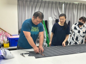 學員廖冠傑(左一)在桃分署「服裝樣版設計班」中學習打版與成衣放縮等技巧，結訓後成功創業。