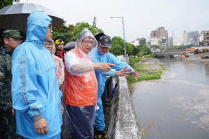 楊文科縣長頂著風雨視察豆子埔溪防颱清淤情形。