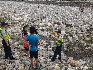 許多民眾到大甲溪河床進行戲水消暑等活動，員警除了宣導戲水安全並勸離危險區域。（記者黃玉鼎攝）