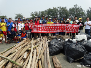 台南市海洋水上運動推廣協會理事長吳俊德（中）帶領潛水伕淨海，岸上的人進行淨灘，大批魚網及蚵架竹子及波麗龍堆積成山，展現淨海淨灘成果。