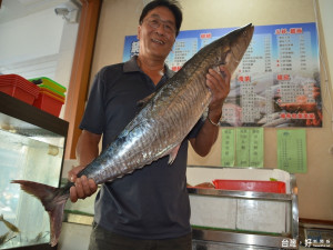 菊島老闆田恆能拿的是澎湖空運今年道批土魠魚。（記者／黃芳祿攝）