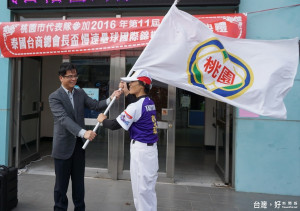 桃園市政府副祕書長邱俊銘授旗，由前壘球國手現任桃園市體育會慢速壘球委員會教練張簡金玲代表接受。