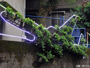 走近八德空軍退員宿舍，迎面而來的是「空軍翱翔天空」的綠色圖示，以繁茂的植栽，搭配環保LED燈，排成飛機的輪廓，作為牆面的綠化景觀