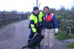 員警蕭時雨與民眾合力將拉不拉多犬從大水溝裡拉起救出。